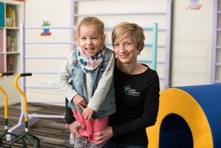 Esther supporting a young girl with developmental progression