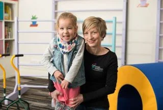Esther supporting a young girl with developmental progression
